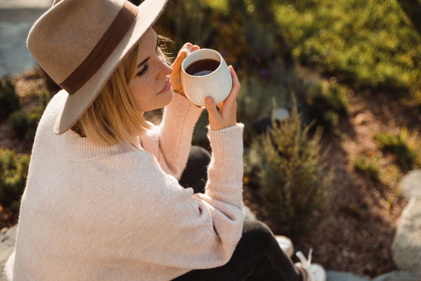 Woman in a cowboy hat drinking coffee