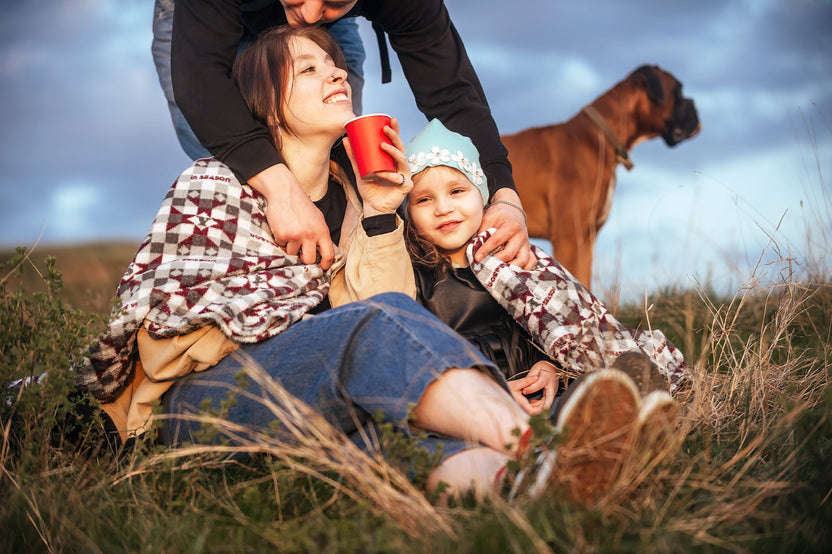 Family and their dog enjoying coffee outdoors